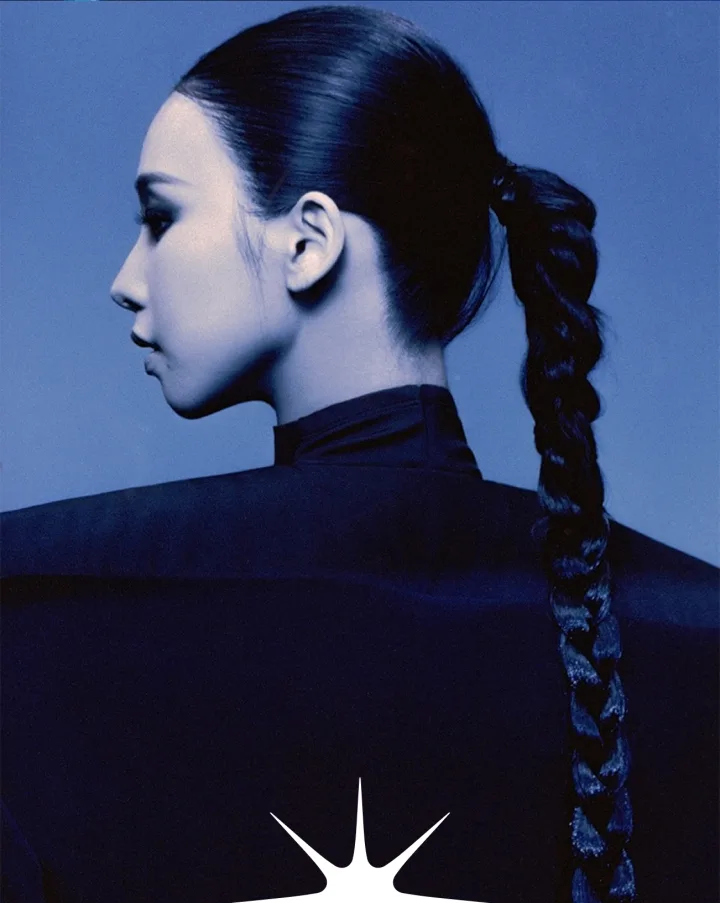 Profile portrait with a long braid, lit in blue, from an AHKET set production