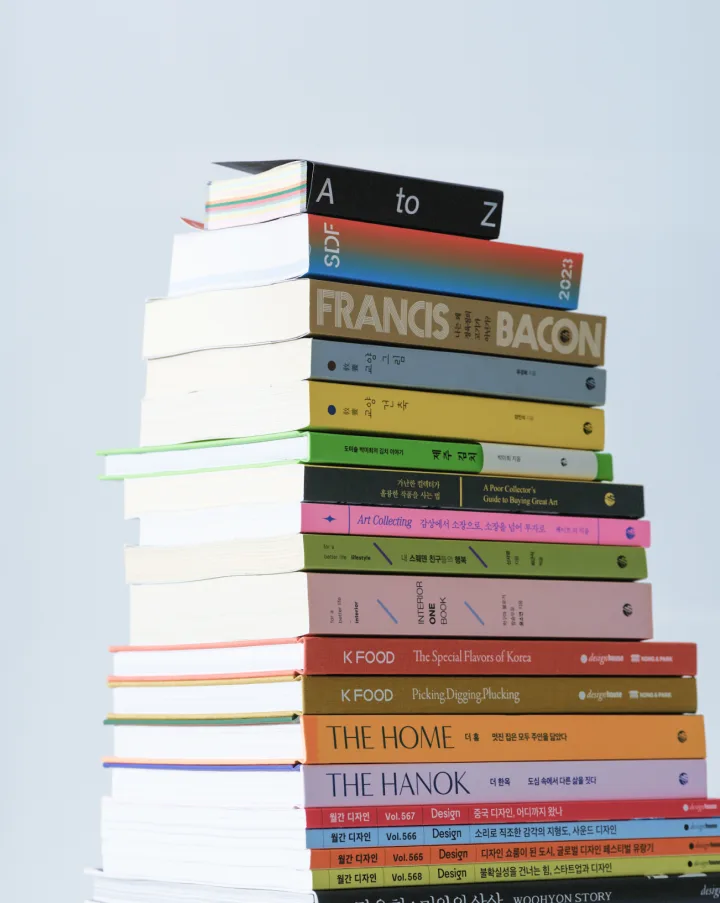 A tall stack of colourful books published by Design House